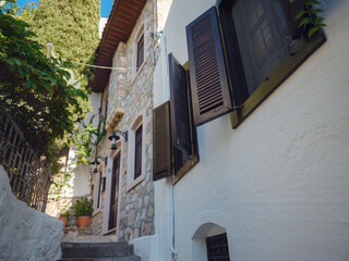 Fototapeta na wymiar Marmaris is resort town on Turkish Riviera, also known as Turquoise Coast. Beautiful streets of old Marmaris. Narrow streets with stairs among houses with white bricks, green plants and flowers
