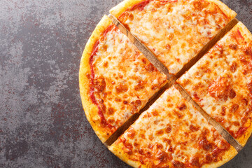 Delicious crispy New York style pizza with melted cheese and base tomato sauce close-up on a wooden...