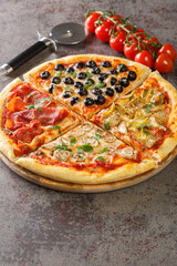 Pizza Four Seasons with Mozzarella cheese, ham, tomato sauce, mushroom, artichokes and olives closeup on the board on the table. Vertical
