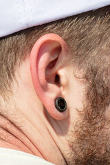 Black earring in a man's ear.