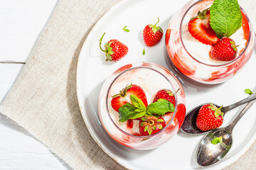 Italian dessert panna cotta in glass with strawberries. Healthy sweet food, hard light, dark shadow
