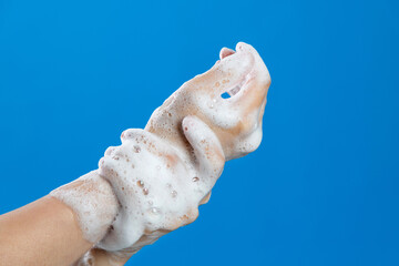 Woman rubbing wrist on blue background