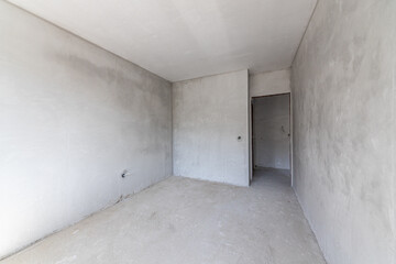 New empty room under construction. Plaster walls. New home. Concrete walls. Interior renovation.