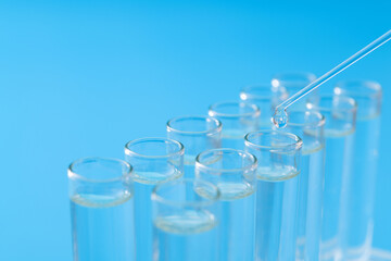 Liquid drop to test tube on blue background