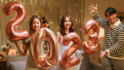 New Year celebration concept, Group of friends holds balloon air pink gold number 2023 in new year...