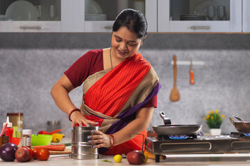 Young woman packing lunch box in kitchen