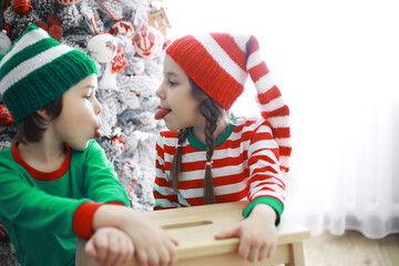 Santa Claus sitting with little cute elves over Christmas background. Time of miracles. Gifts from Santa Claus.