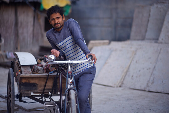 Portrait of a rickshaw puller with his rickshaw and his workload 