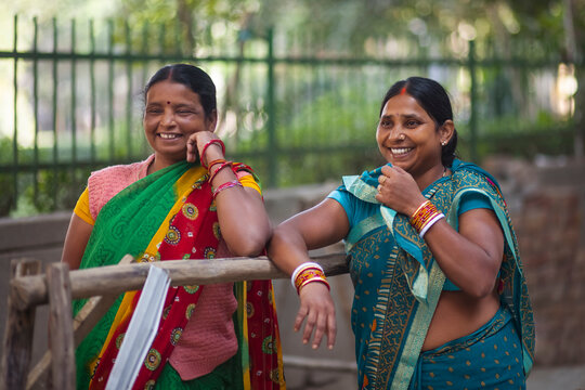 Two maids standing and chatting on the street 
