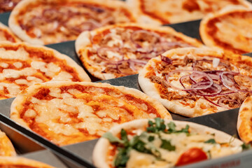 Many Italian pizza on the counter of the bakery store