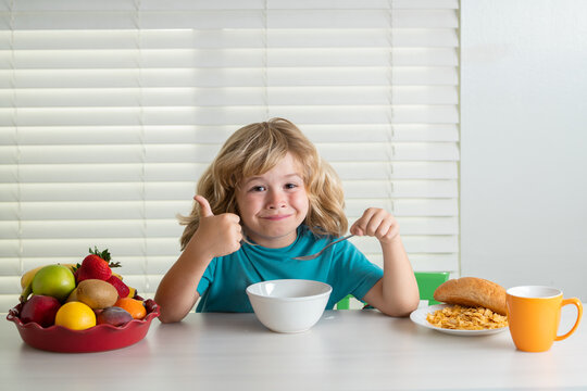 Schoolchild Eating Breakfast Before School. Portrait Of Little Teen Child Sit At Desk At Home Kitchen Have Delicious Tasty Nutritious Breakfast.