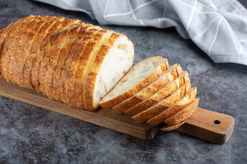 Fresh white loaf of bread on gray cement background. Top view