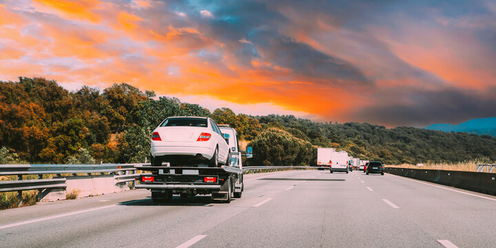 Tow Truck Transporting Car Or Help On Road Transports Wrecker Broken Car. Car Service Transportation Concept. Auto Towing, Tow Truck For Transportation Faults And Emergency Cars . Tow Truck Moving In