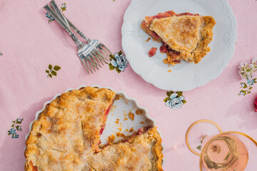 single slice of rhubarb pie on white plate, pink tablecloth with blue roses