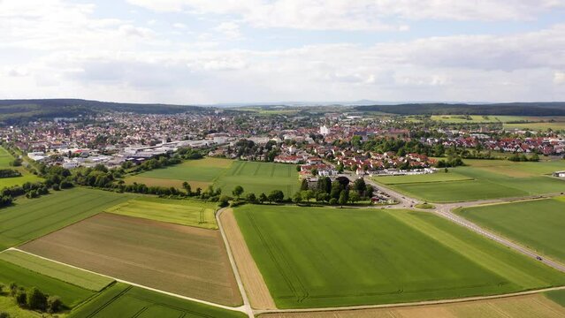 Aerial Flying Over Countryside Fields With View Of Butzbach In Background. Establishing Shot