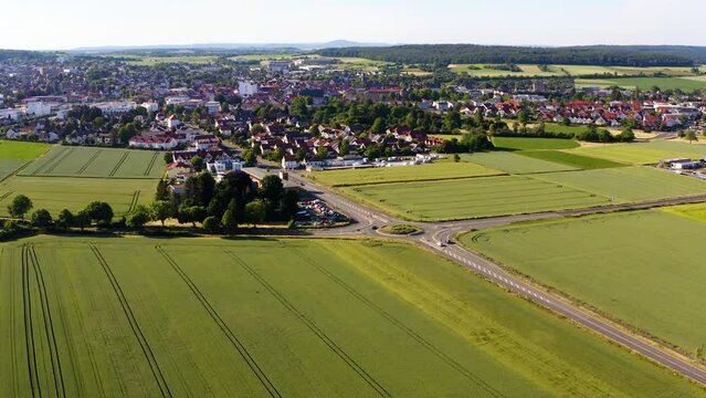 Aerial View Over Countryside Fields With View Roundabout And Road Leading To Butzbach In Background. Establishing Shot, Dolly Forward