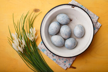 Easter in Ukraine 2022. Ukrainian flag colors: blue painted Easter eggs on yellow background. Top view