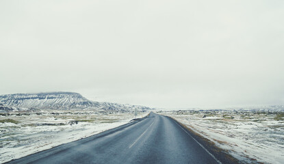 Empty road across snowy field landscape photo. Beautiful nature scenery photography with mountain on background. Idyllic scene. High quality picture for wallpaper, travel blog, magazine, article © Gypsy On The Road