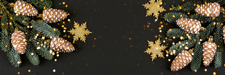 Christmas decorations in the form of golden cones and snowflakes on a black background with...