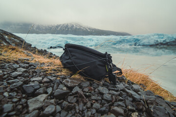 Close up container for camera on ground concept photo. Cameraman equipment. Front view photography with ice mountains on background. High quality picture for wallpaper, travel blog, magazine, article