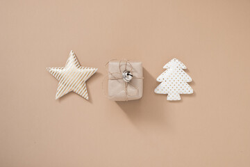Christmas composition. Christmas gift box, star and christmas tree on pastel beige background