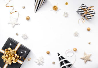 Christmas composition. Christmas gifts, party hats, black and gold decorations on white background. Flat lay, copy space