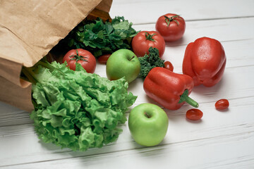 bag of fresh vegetables on a light wooden background .