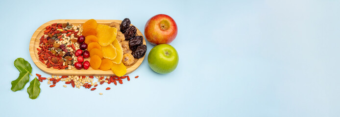 Festive Tu Bishvat background. Dried berries, apricots, mangoes, nuts, apples on a wooden tray....