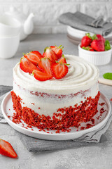 Red velvet cake with fresh strawberries. Festive layered cake from red sponge cakes and cream...