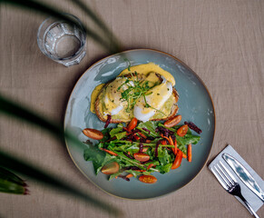 Vegetarian egg Benedict and fresh salad on the plate