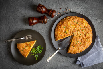 Spanish omelette with potatoes, typical spanish cuisine on gray concrete floor. Tortilla Espanola. Turkish name; Yumurtali patates
