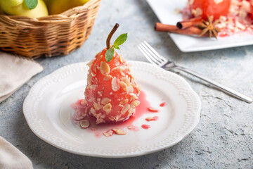 A poached pear dessert sprinkled with almond pieces. A taste of Turkish desserts, pear dessert. Poached pears in red wine.