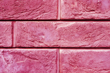 pattern of decorative pink slate stone wall surface as a background. toned in viva magenta, trend...