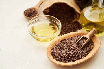 flaxseed linseed and oil in wood bowl on white table background. flaxseed linseed oil and bag. flaxseed linseed oil                                                              