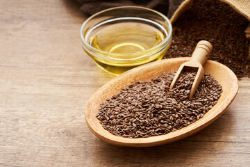 flaxseed linseed and oil in wood bowl on wooden table background. flaxseed linseed oil and bag. flaxseed linseed oil                                                      