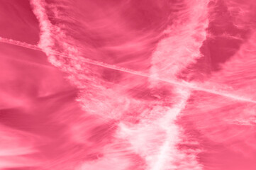background of beautiful bright red pink purple day sky with white cirrus clouds and trail from the...