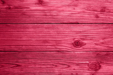 wooden board background. aged weathered red pink purple timber wood planks. toned in viva magenta, trend color of the year 2023