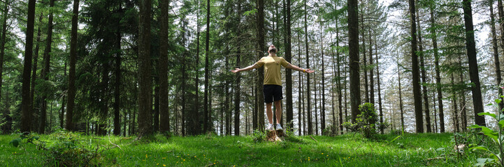 man breathes fresh air in the forest, catching a ray of sunshine