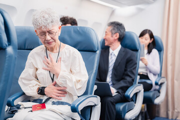 Fototapeta na wymiar 飛行機の機内で体調不良に苦しむ高齢の女性