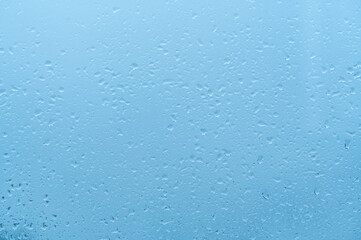 Water Drops Background. Rain drops on window, blue background. Drops Of Rain Water at dawn with blue Light On Glass Background. blue background drops glass abstract texture