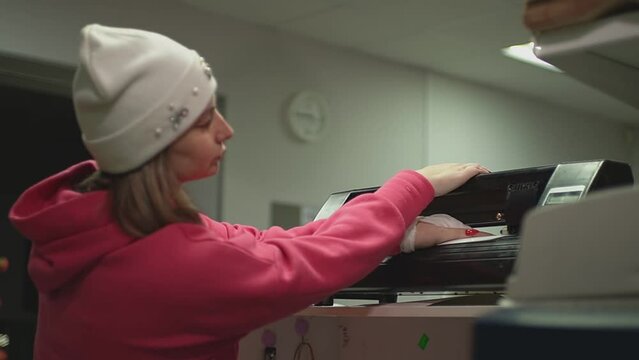 the girl sets the plotter to work so that it cuts out a certain pattern. High quality Full HD video recording