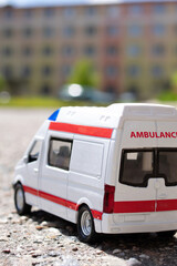 Fototapeta premium Model of an ambulance car on the background of the city