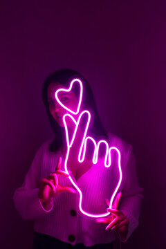Beautiful girl with neon signs. Pink neon sign love and like. Trendy style. Neon sign. Custom neon. Home decor.