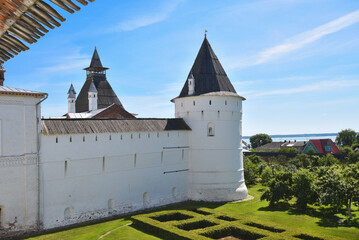 the walls of the Rostov Kremlin with towers on a sunny summer day