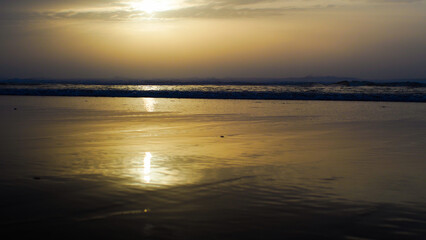 Naklejka premium Coucher de soleil chaleureux sur la plage de Moliets-et-Mâa, par un temps couvert, en période hivernale