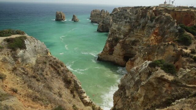 People walking the long staircase composed of 182 steps leading to the base of cliffs of Ponta da Piedade in Lagos Bay. Famous tourist attraction in Algarve Coast in Lagos, Portugal.