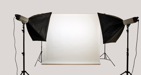 Two soft box on stand illuminated a white background in photo studio.