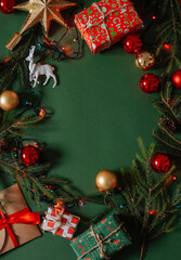 Christmas presents layout on green festive backdrop. Winter holidays concept