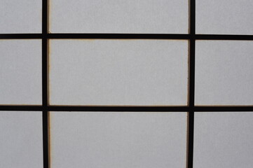 Rectangular and square Japanese shoji paper window frame with partitions with light in Japan