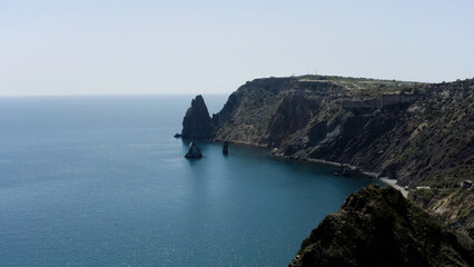 A beautiful bird's-eye view of the landscape. Action . A view of the blue ocean, mountains and green trees standing on them and you can see small sails that float near the shore.